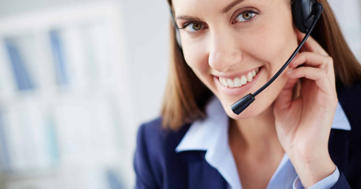 Young businesswoman with headset looking at camera with smile